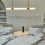 Reception and waiting area at KT Aesthetics House of Beauty medical spa in Little Rock, Arkansas, featuring a custom reception desk and retail display by Rye General Contractors