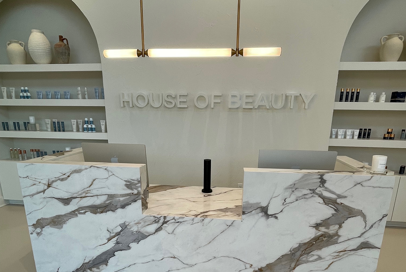 Reception and waiting area at KT Aesthetics House of Beauty medical spa in Little Rock, Arkansas, featuring a custom reception desk and retail display by Rye General Contractors
