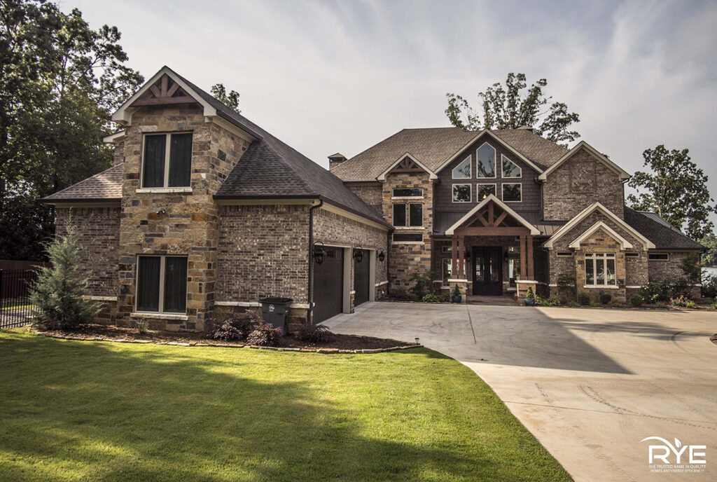 Brick exterior of a custom lakeshore home in Hot Springs, Arkansas with brown gable details, built by Rye General Contractors
