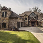 Brick exterior of a custom lakeshore home in Hot Springs, Arkansas with brown gable details, built by Rye General Contractors