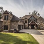 Brick exterior of a custom lakeshore home in Hot Springs, Arkansas with brown gable details, built by Rye General Contractors