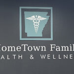 Reception and check-in area at Hometown Health and Wellness clinic in Benton, Arkansas featuring a logo wall and welcoming entry by Rye General Contractors
